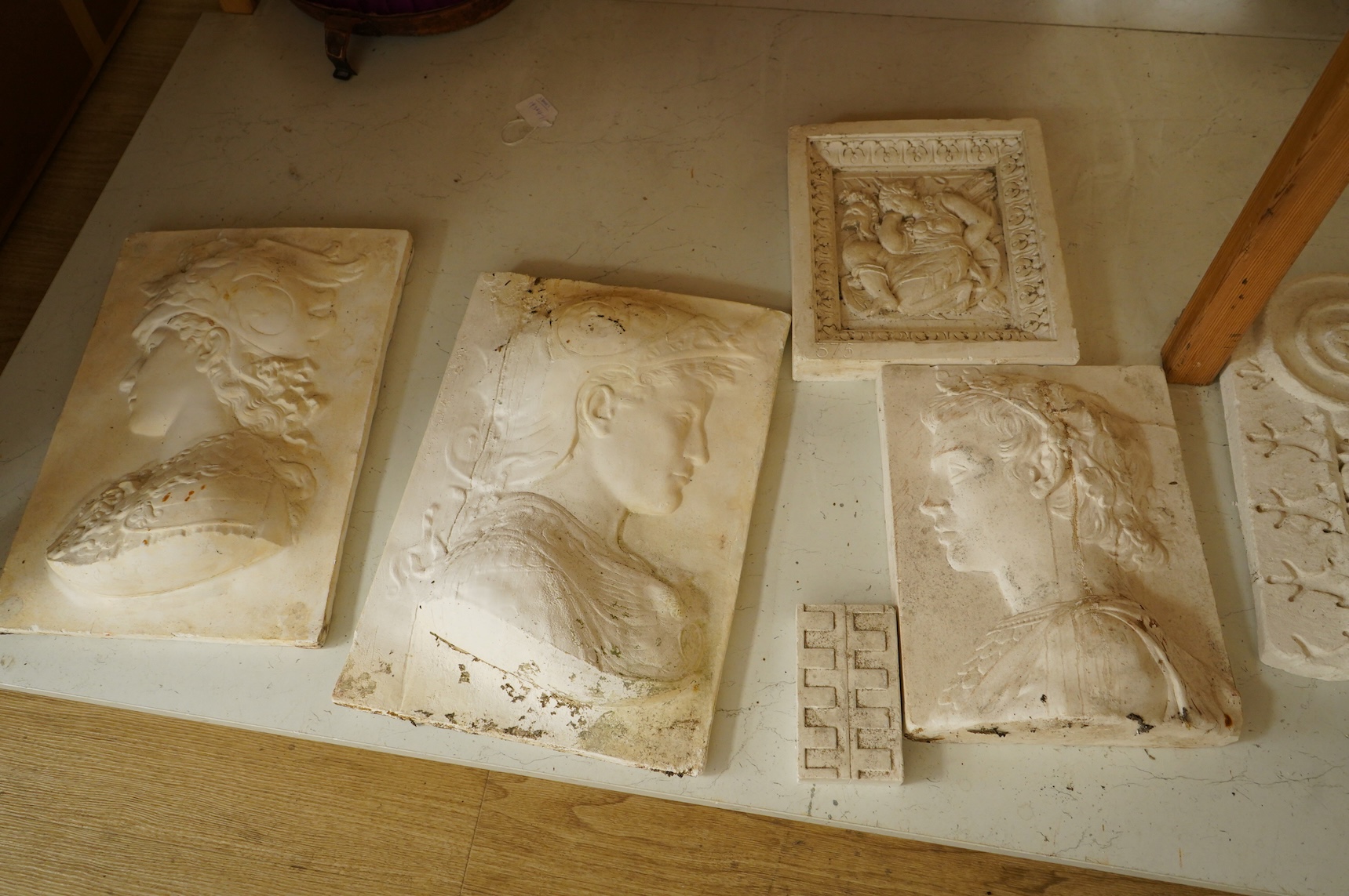 A collection of plaster-cast relief panels to include classical busts and foliage, largest 47cm high